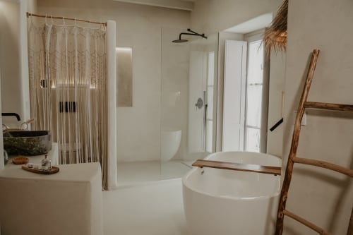 Salle de bain minimaliste à EntreArcos Eco-Boutique avec baignoire, douche cascade, rideau en macramé, accents bois et vue ville