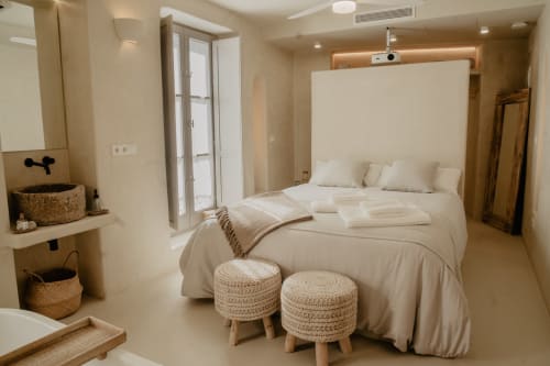 Chambre moderne à EntreArcos Eco-Boutique à Vejer de la Frontera avec lit blanc, poufs tissés et décoration minimaliste