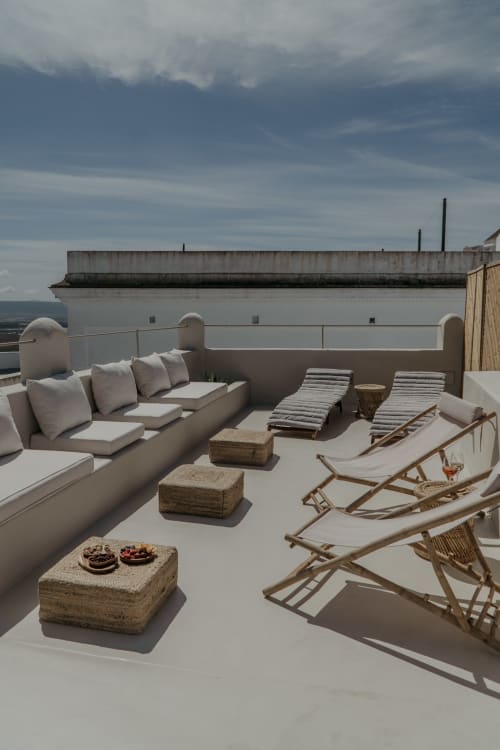 Terrasse sur le toit d'EntreArcos Eco-Boutique à Vejer de la Frontera avec sièges, transats et vue sur la ville