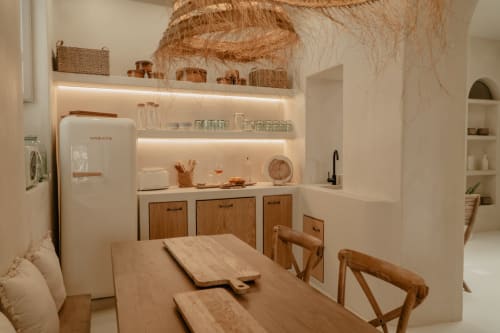 Petite cuisine moderne et lumineuse avec électroménagers crème, placards en bois et table à manger au cottage EntreArcos Eco-Boutique