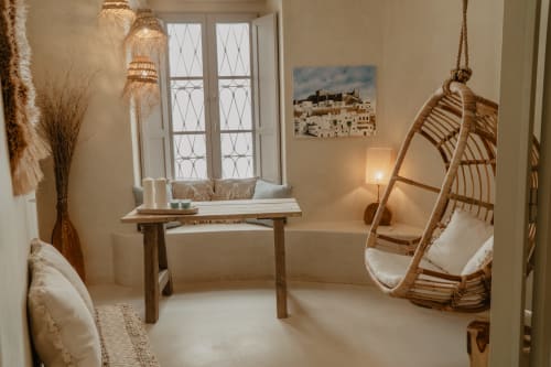 Chambre minimaliste et lumineuse à EntreArcos Eco-Boutique avec fauteuil suspendu tressé, banc en bois près de la fenêtre, Vejer de la Frontera