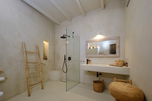 Salle de bain écologique moderne à Vejer de la Frontera avec douche à l'italienne, lavabo suspendu et détails en bois naturel