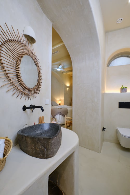 Salle de bain moderne avec lavabo en pierre et miroir décoratif du gîte EntreArcos Eco-Boutique à Vejer de la Frontera