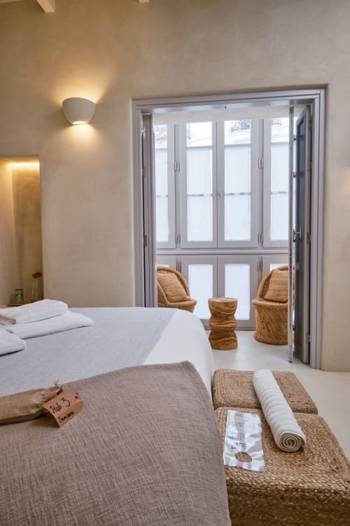 Chambre moderne à EntreArcos Eco-Boutique à Véjer de la Frontera avec lit, accès à la terrasse, chaises tissées et vues sur la ville