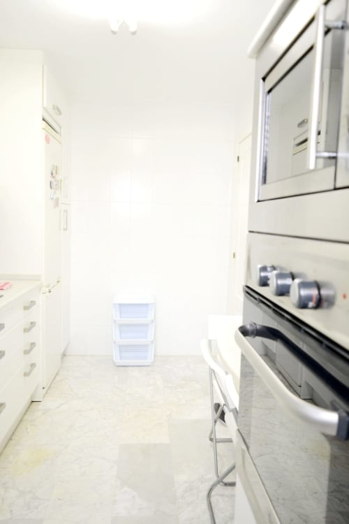 Modern kitchen interior at Royal Banus, Marbella with white appliances and storage containers