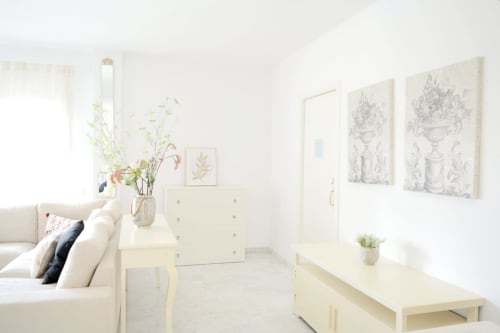 Bright, minimalist living room at Royal Banus Marbella with cream sofa, modern furnishings, and botanical artwork