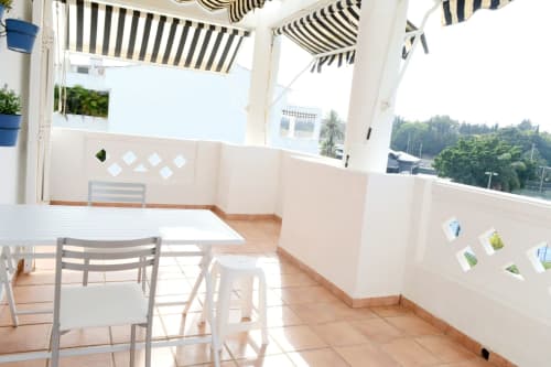 Bright terrace at Royal Banus Marbella with striped awning, dining area, and mountain views over the Costa del Sol