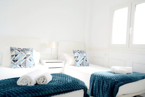 Two twin beds with blue patterned pillows and rolled towels at Royal Banus hotel in Marbella