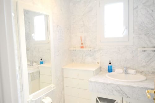 Luxury marble bathroom at Royal Banus Marbella with dual sinks, modern fixtures, and bright natural lighting
