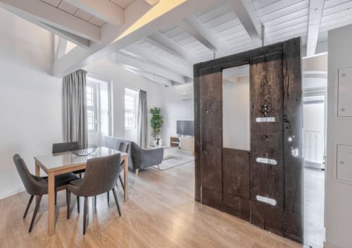 Modern duplex apartment at Porto hotel with dining table, sofa, wooden beams, and dark sliding barn doors