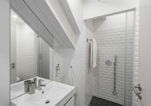 Modern bathroom at Oporto Comfort Dom Hugo, Porto: white subway tile walls, glass shower enclosure, sink vanity with mirror