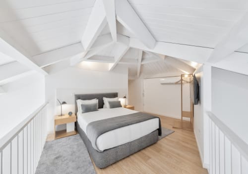 Modern loft bedroom at Oporto Comfort Dom Hugo with queen bed, skylight, wooden floors, and city views in Porto