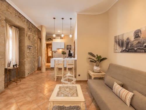 Sala de estar moderna del loft Peperete en Baiona con cocina, comedor, sofá y accesorios decorativos