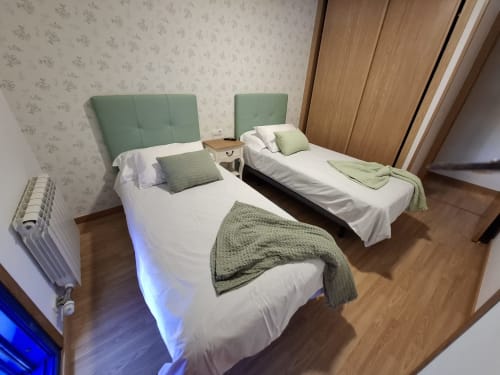 Amplio dormitorio doble en Houses by Pilar, Sotomayor con cabeceros verdes, ropa de cama blanca, suelos de madera y moderno