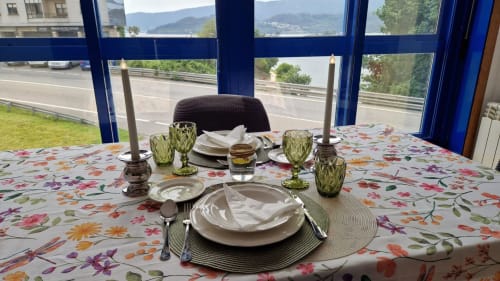 Elegante configuración de comedor en Houses by Pilar Sotomayor con vistas a las montañas a través de ventanas con marcos azules
