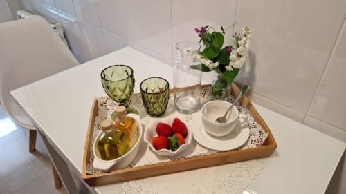 Bandeja de bienvenida elegante en Houses by Pilar Sotomayor con fresas frescas, aceite de oliva, copas, servicio de té y flores