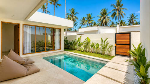 Oasis Dune Villas private villa in Lombok with turquoise pool, white modern design, palm trees, and tropical garden