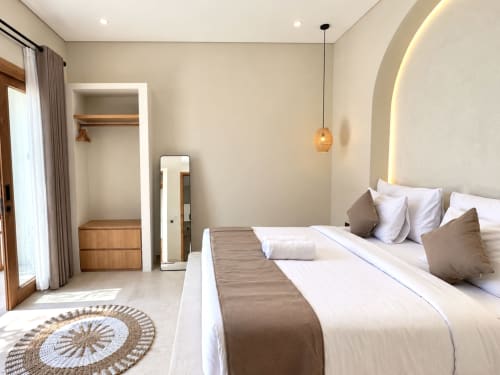 Dormitorio moderno en Oasis Dune Villas, Lombok, con cama king, iluminación cálida, vestidor y diseño minimalista
