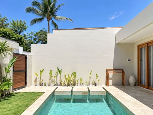 Piscina privada de Oasis Dune Villas con agua turquesa, villa blanca moderna, jardín tropical y palmeras en Lombok