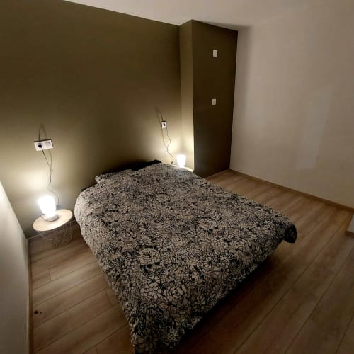 Chambre douillette aux Hortensias B&B à Bourbonne-les-Bains avec couvre-lit à motifs et lampe de chevet