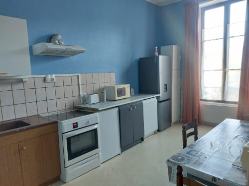 Cuisine moderne de l'appartement Les Hortensias à Bourbonne-les-Bains, murs bleus, électroménager blanc et bien équipée