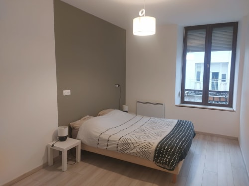 Chambre moderne aux Hortensias B&B à Bourbonne-les-Bains avec lit double, luminaire suspendu et vue sur la ville