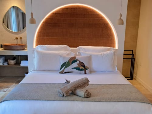 Chambre moderne aux Terrasses de Lorgues avec tête de lit en cuivre illuminée, literie blanche et coussins décoratifs
