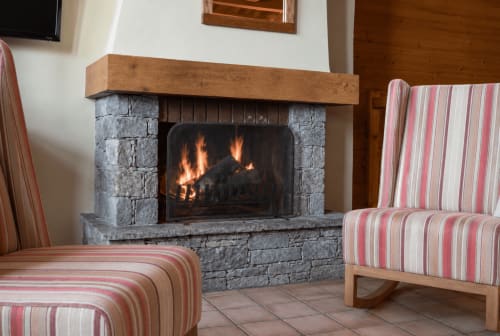 Salon douillet avec cheminée et fauteuils rayés au Chalet des Cimes, Belle Plagne