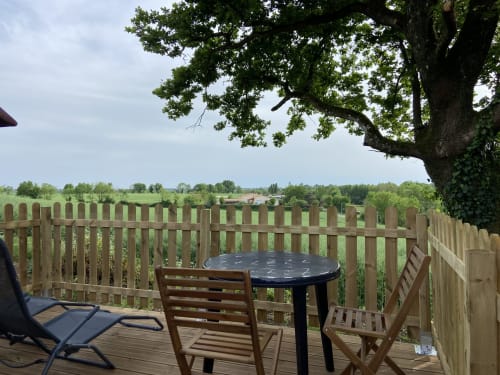 Terrasse en bois avec table et chaises avec vue sur la campagne au Petit Moulin, Pouzauges
