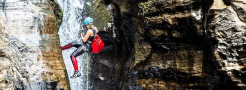 Rock climber scaling waterfall in athletic gear near Golden Mermaid Villa, Ribeirinha Portugal adventure activity
