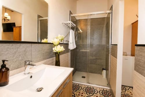 Modern bathroom at Serranía in Chulilla with walk-in shower, white sink, and decorative tilework