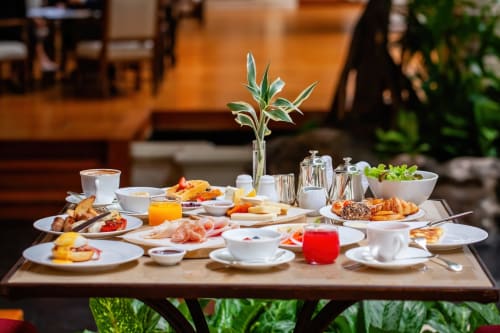 Petit-déjeuner raffiné à la Maison Crone avec viennoiseries, fruits frais, jus et fleurs à Castillon-en-Couserans