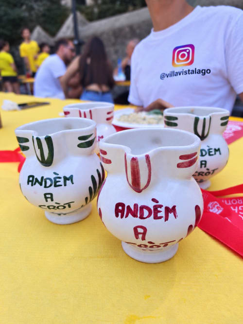 Hand-painted ceramic bowls with "Andém a Crot" text at Villa Vista Lago event, Bellano Como