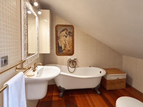 Lujoso baño abuhardillado en Baiona con bañera exenta, lavabo pedestal, suelos de madera y vistas al mar