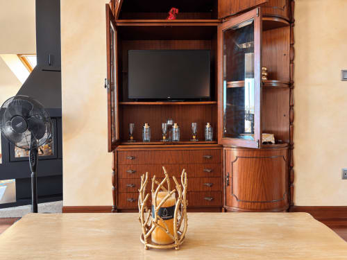 Elegante mueble de madera con televisor y cristalería en el apartamento Lembrare de Holibai, Baiona
