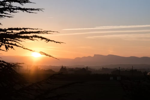 Lever de soleil sur la vallée de Sauzet aux Buis de Fontjuliane, lumière dorée illuminant montagnes et paysage champêtre
