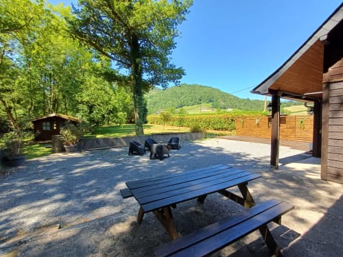 Outdoor patio with picnic table at Le gîte des Mousquetaires cottage in Lanne en Baretous, France, overlooking green