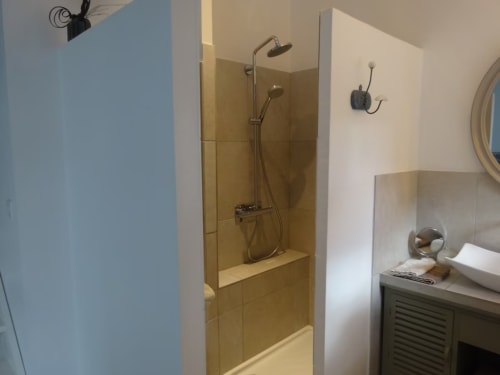 Salle de bain moderne avec douche à l'italienne, lavabo et équipements au gîte Les buis de Fontjuliane à Sauzet, France