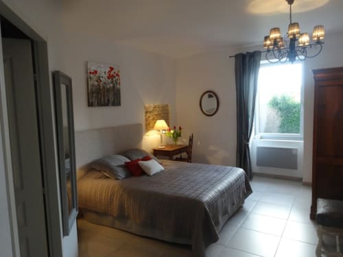 Chambre double lumineuse aux Buis de Fontjuliane avec vue sur le jardin, éclairage élégant et mobilier confortable