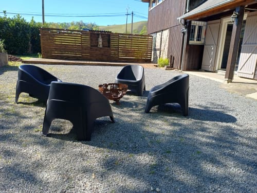 Outdoor seating area with black modern chairs around fire pit at Le gite des mousquetaires cottage in Lanne en Baretous