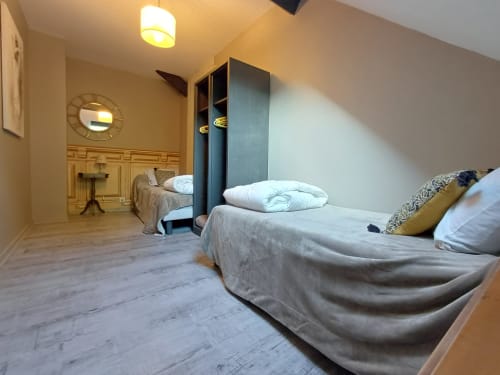 Spacious bedroom at Le gite des mousquetaires in Lanne en Baretous with two beds, wooden floors, and modern amenities.