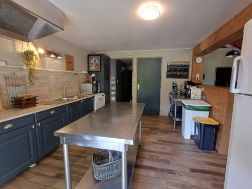 Modern cottage kitchen with stainless steel island, dark blue cabinetry, and wood floors at Le gite des mousquetaires, LANNE