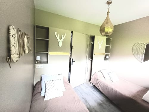 Twin bedroom at Le gite des mousquetaires B&B in Lanne en Baretous, France with modern décor and pendant lighting