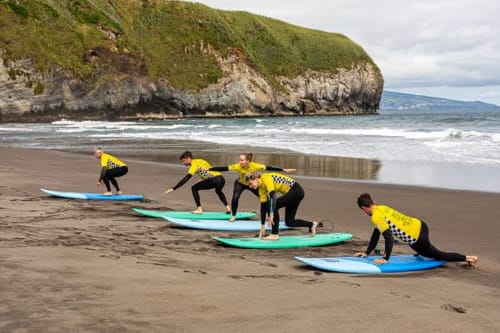 Surfing lesson group in yellow shirts on beach near Golden Mermaid Villa, Ribeirinha Portugal