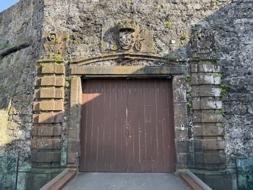 Historic stone entrance with wooden door at Golden Mermaid Villa, Ribeirinha Portugal
