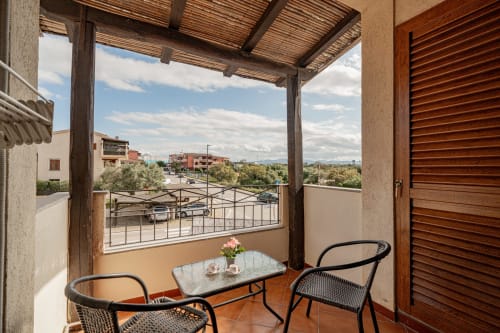 Terrace seating area at Short Let's Olbia with table, chairs, and panoramic views of the Sardinian landscape and surrounding