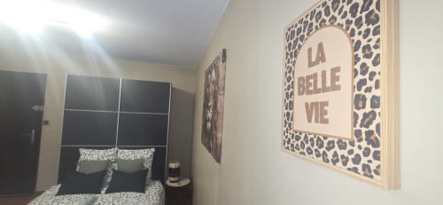 Modern bedroom at NN Patrimoine Le Cocon in Douvaine with leopard print decor, black bed, and 'La Belle Vie' wall art
