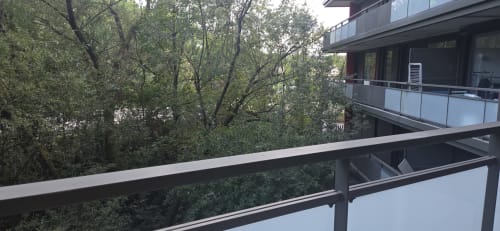 Balcony view at NN Patrimoine hotel in Douvaine with forest views and modern railing overlooking trees