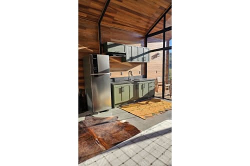 Cozinha moderna da Cabana Nórdica em The Ranch Project.Co, Gonçalves, com eletrodomésticos em aço inoxidável e teto de madeira