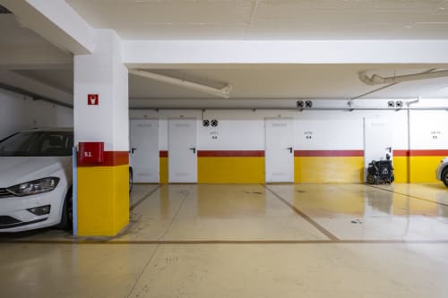 Underground parking garage at RB Algarve with white car, yellow and red barrier posts, and numbered spaces